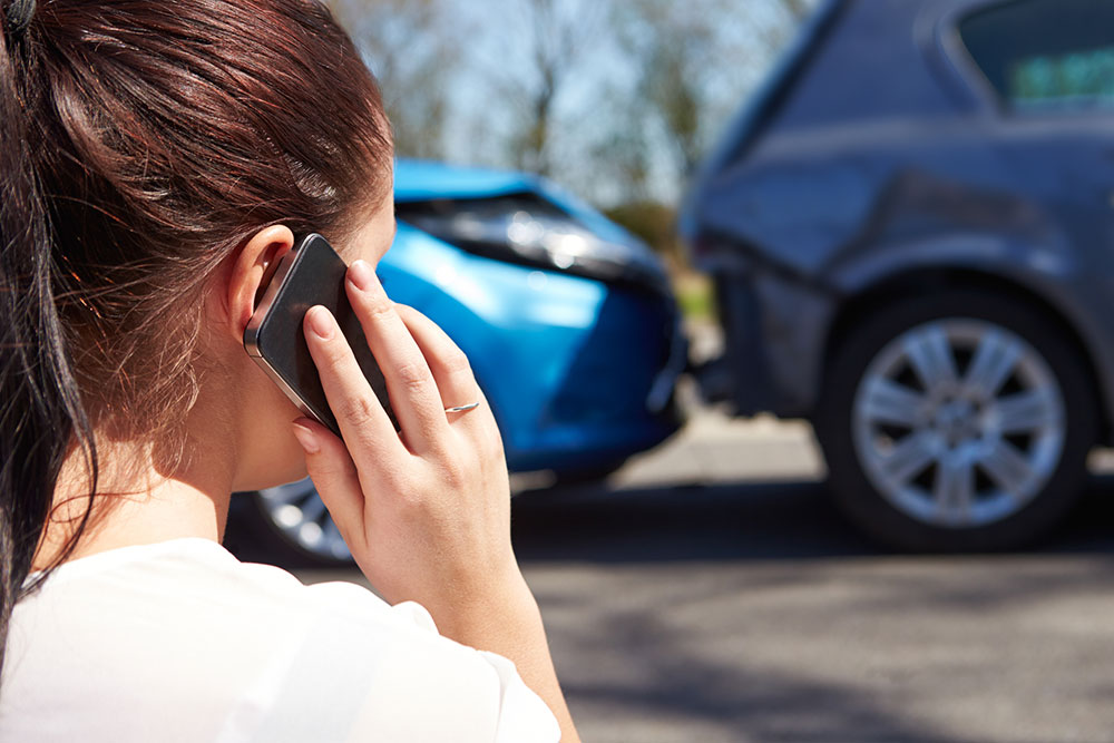 Woman on the phone with her insurer after a car crash