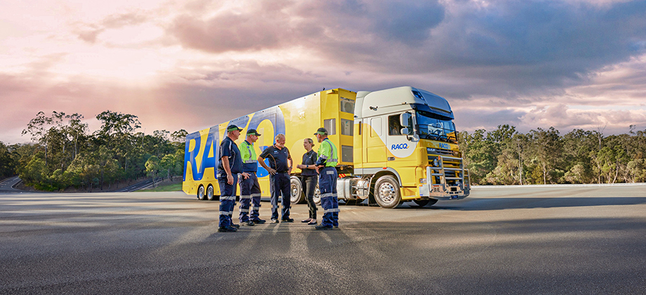 RACQ team in front of truck with sunset