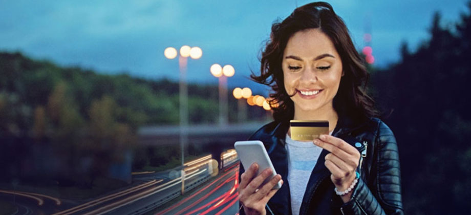 Woman-standing-on-highway-with-credit-card-and-phone-920x420