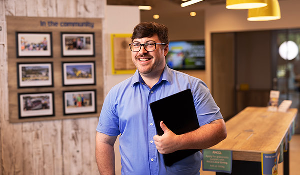 RACQ staff member with laptop in office