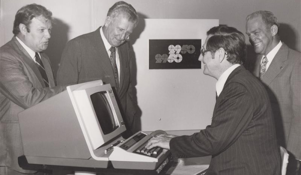 black and white negative of 4 RACQ office workers using computer