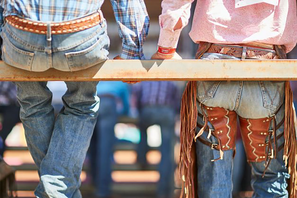 Cowboys sitting on a rail