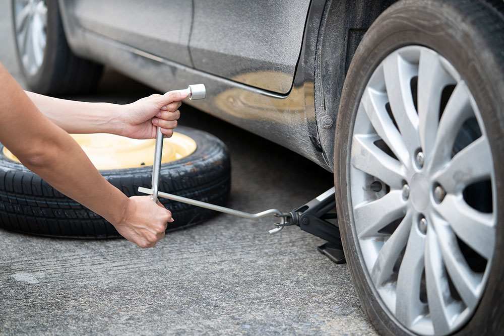 Car jack being used to change car tyre.