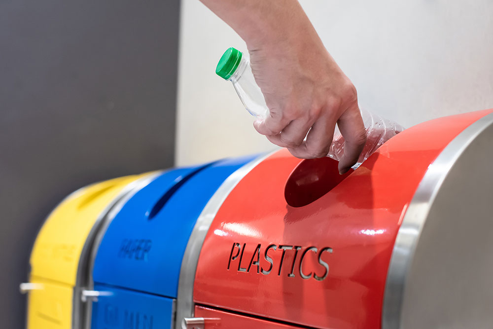 Plastic bottle being put in recycling bin.