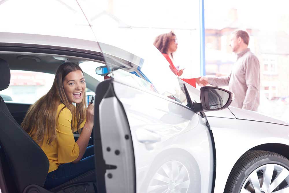 young woman in new car