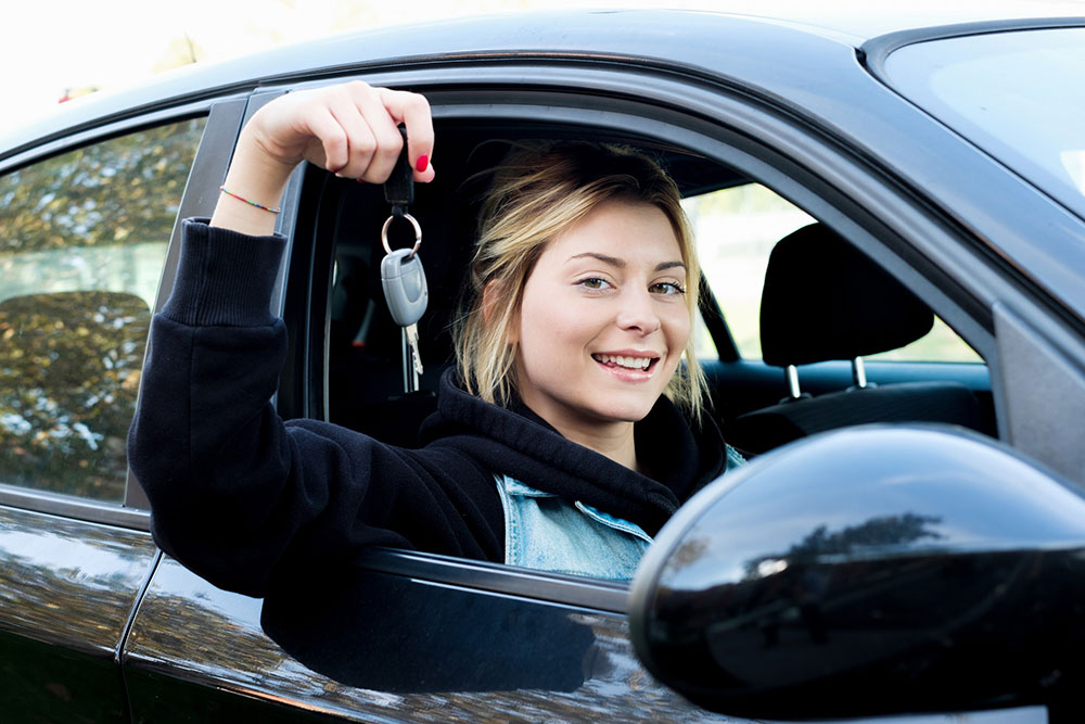 Young girl with keys to first car.
