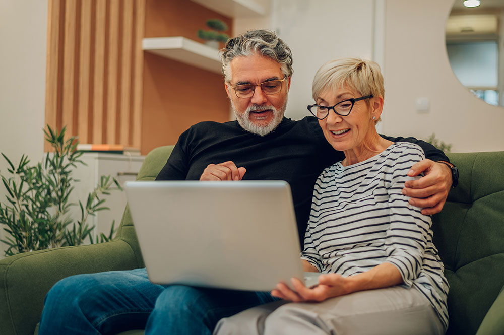 Middle-aged couple looking at laptop.