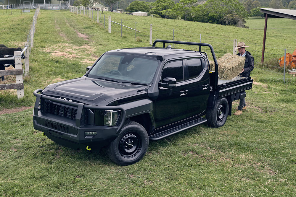 A farmer loading the tray of his Kia Tasman ute.