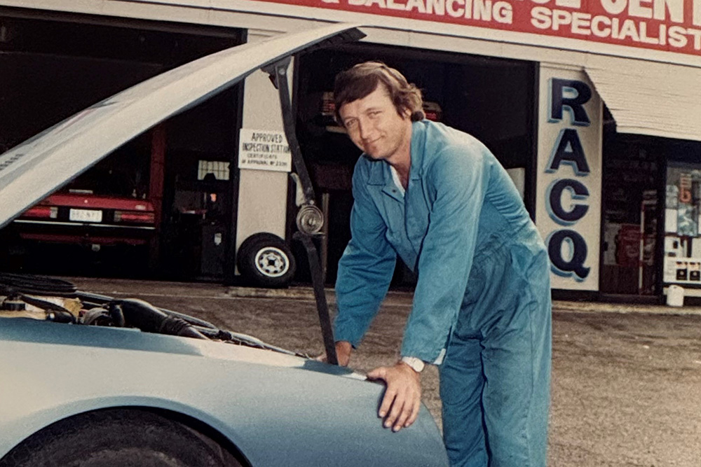 A younger Rob Smith checks a car.