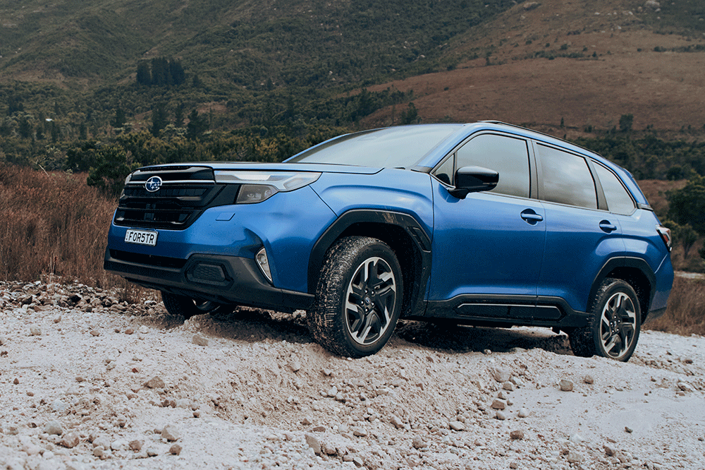 Side view of sixth-generation Subaru Forester on dirt road.
