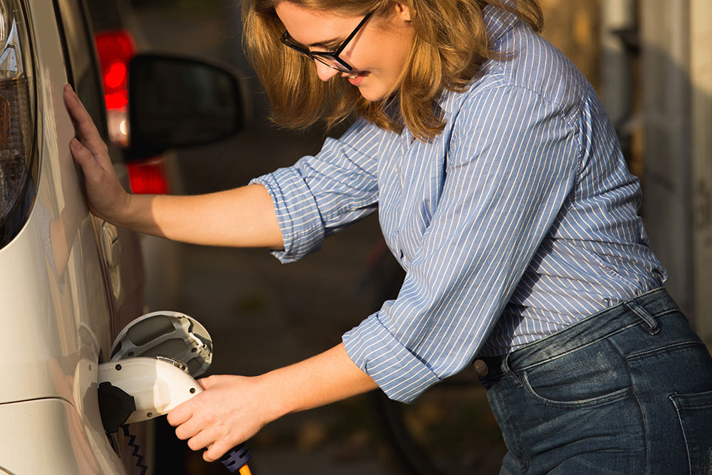 Woman charging and electric car.