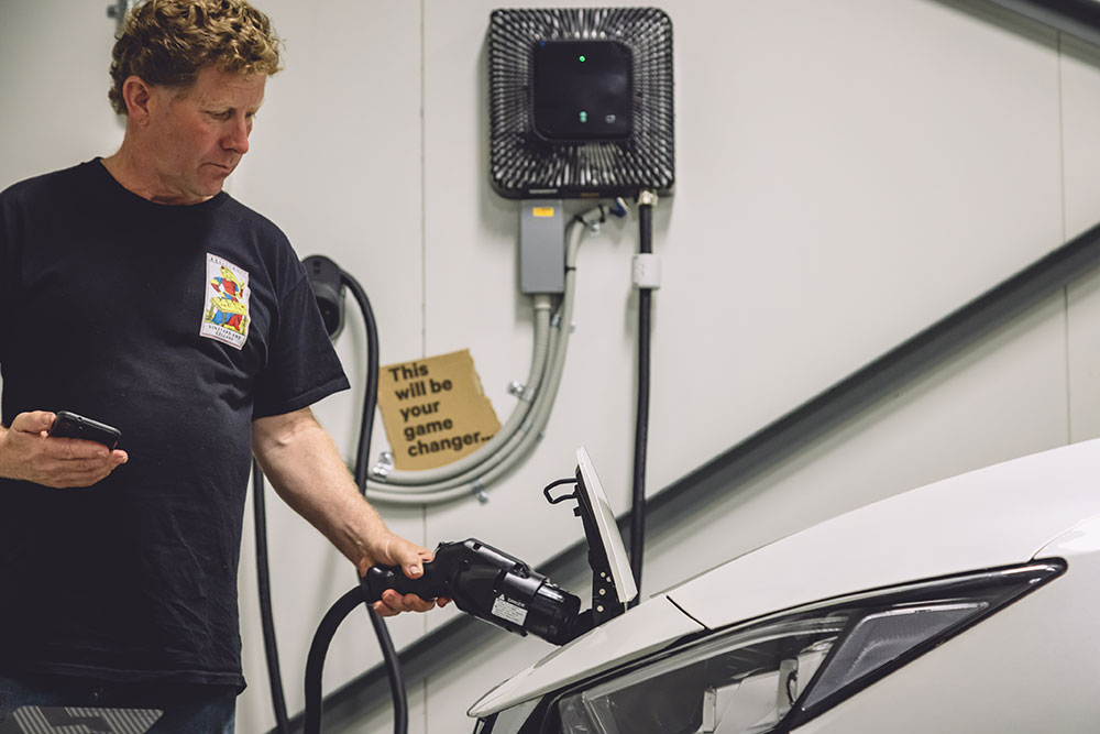Nissan Leaf being used to power a home and business at night.