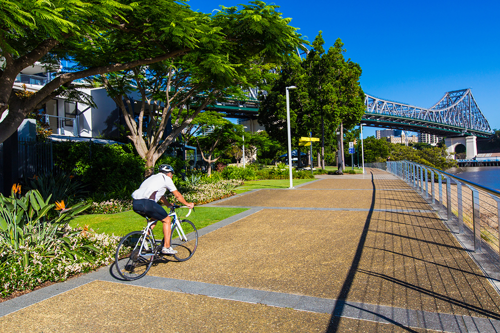 Man riding a bike on a pathway at Kangaroo Point, Brisbane.
