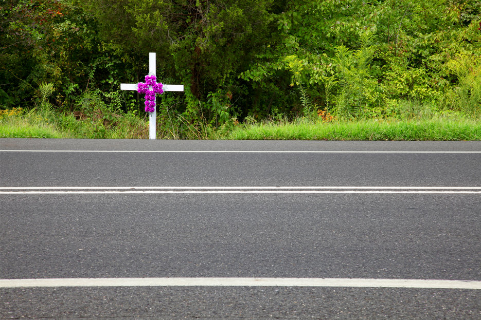 roadside cross with purple flowers
