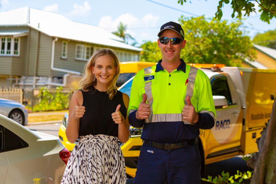 woman with racq road assistance worker giving four thumbs up