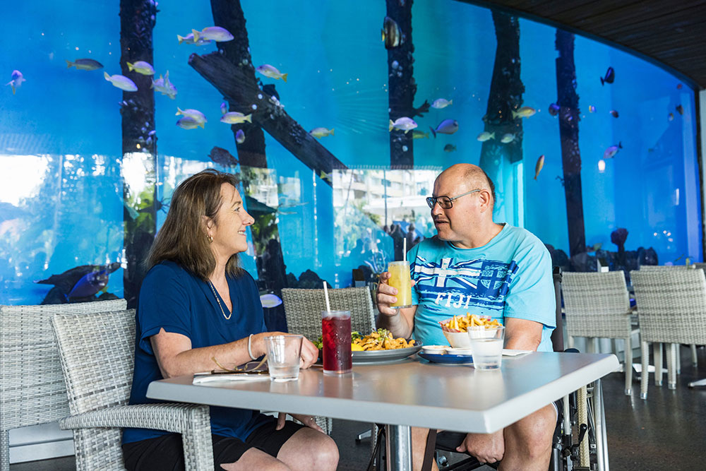Two people enjoy lunch at Cairns Aquarium.