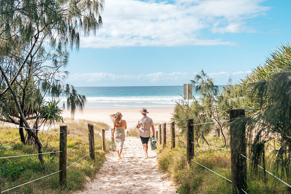 Couple walking on to the Beach at Coolum Sunshine Coast