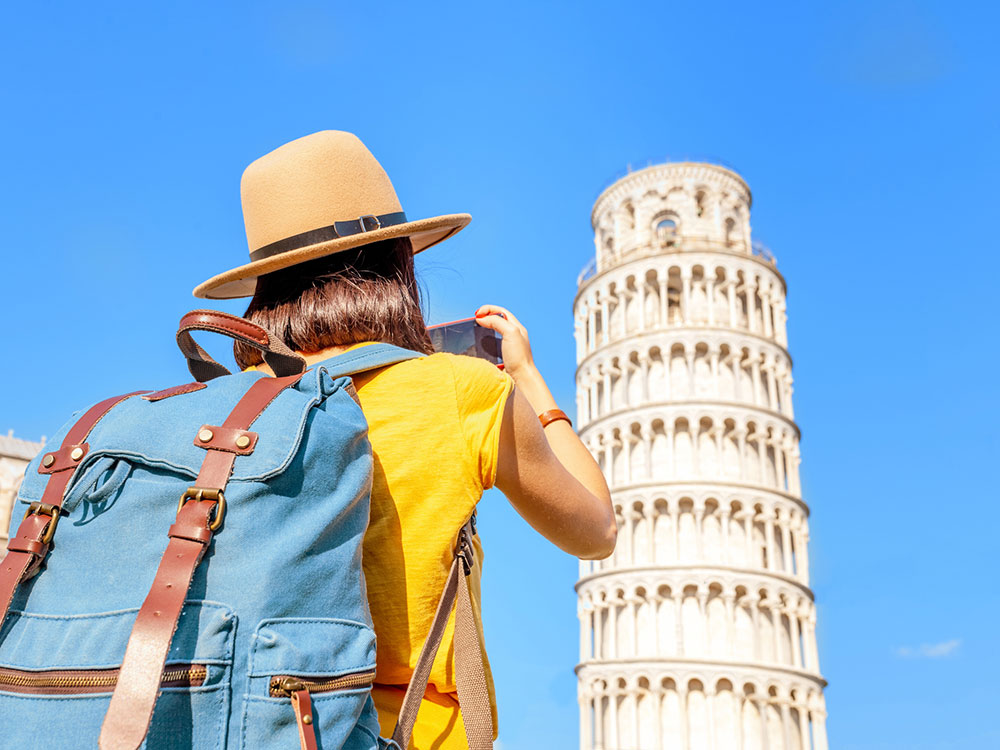 Woman photographing Tower of Piza.
