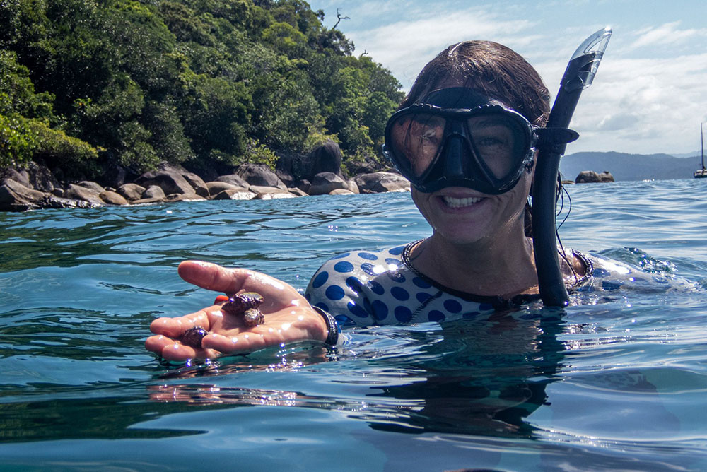 Fitzroy Island Resort marine biologist Laura Pederson with a coral-eating drupella snails.