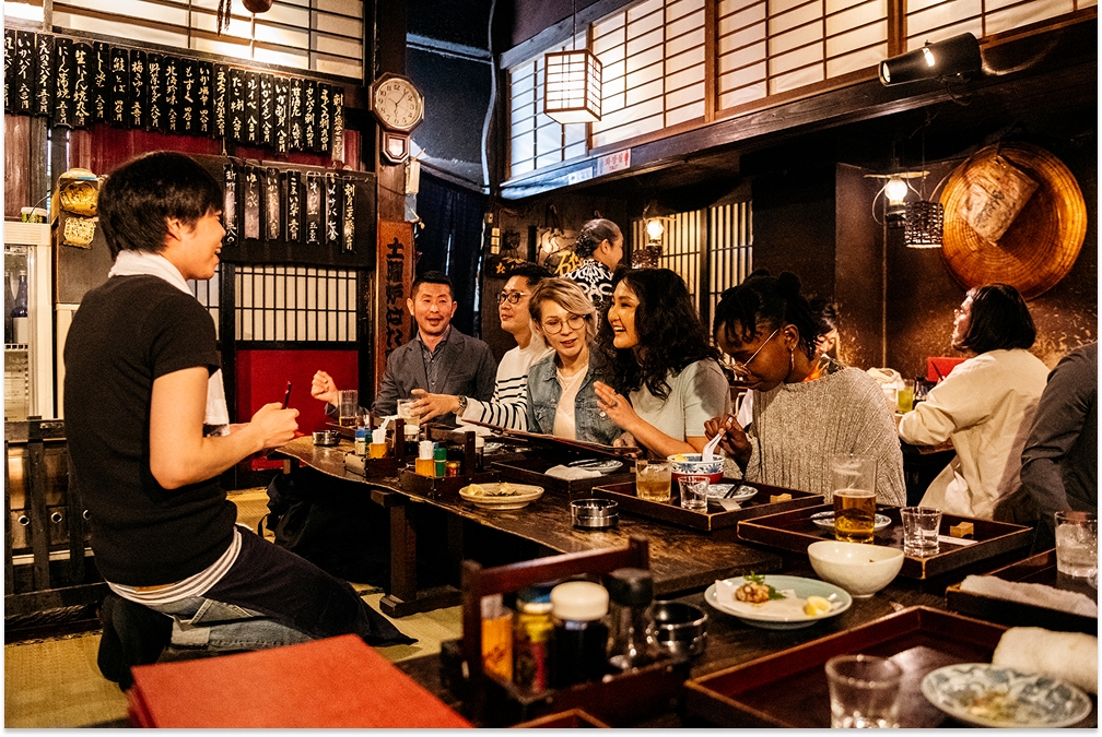 Group of friends ordering food in Japanese Izakaya