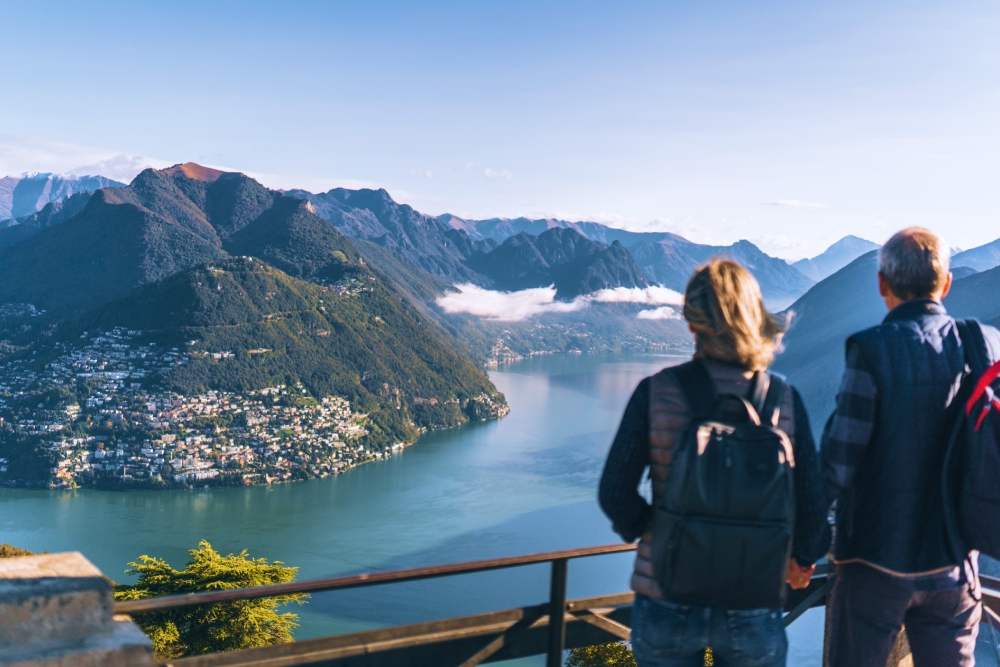 mature couple hiking above lake Lugano in the morning