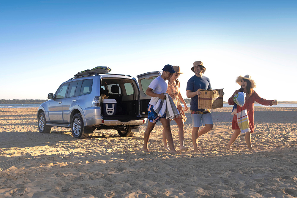 family laughing walking on qld beach