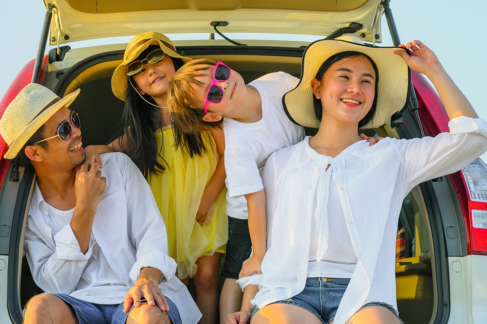 Happy family on a road trip wearing hats and sunglasses