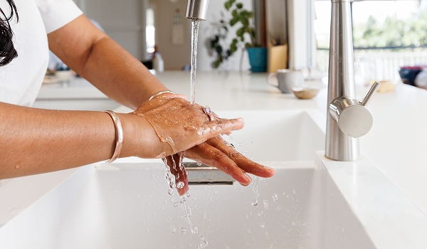 Person washing their hands in the kitchen