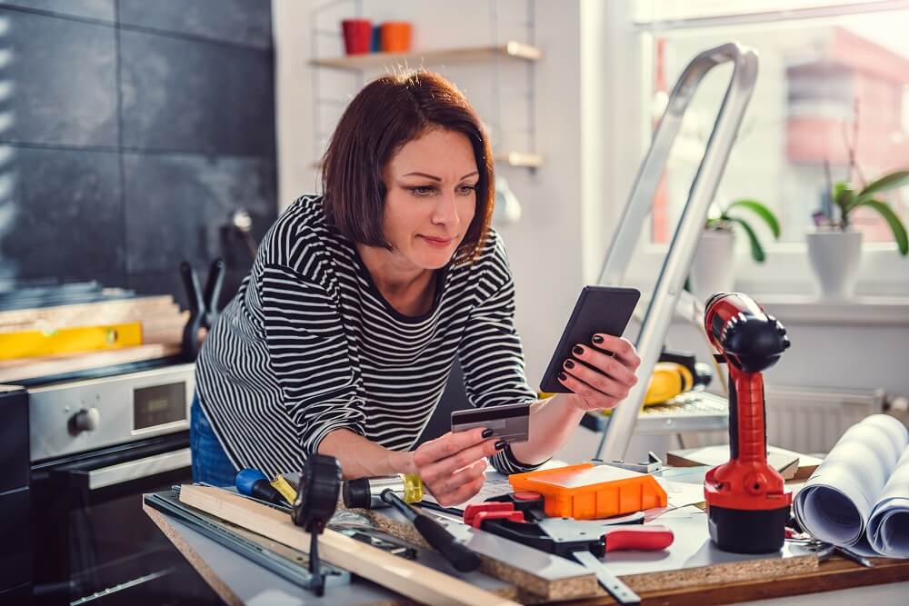 Woman buying tools on her mobile to finish home renovation
