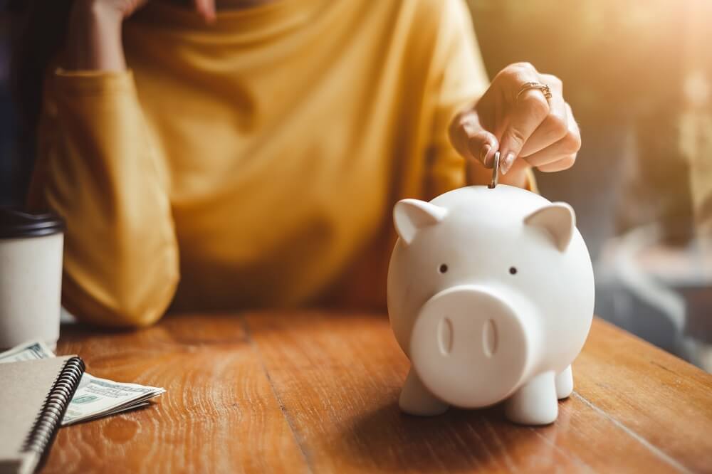 Woman putting a coin in a piggy bank