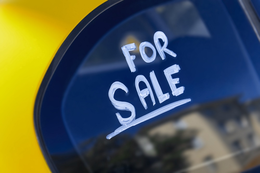 Yellow car with for sale sign on window