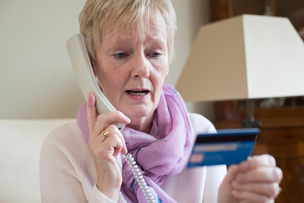 Senior woman reading credit card details out over the phone