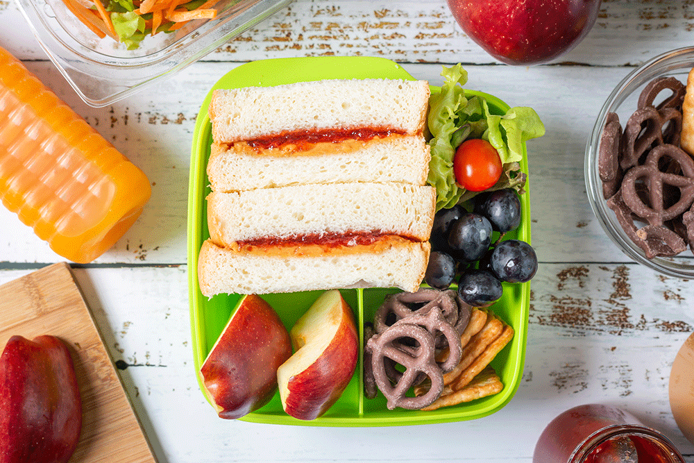 School lunchbox with sandwich fruit chocolate juice