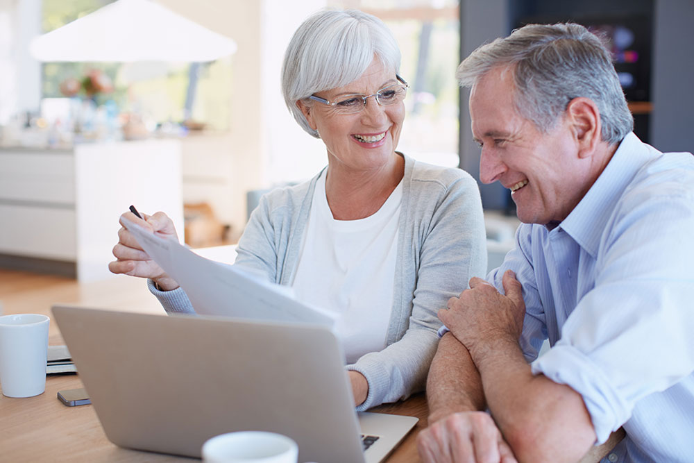 Older couple looking at a computer and paperwork