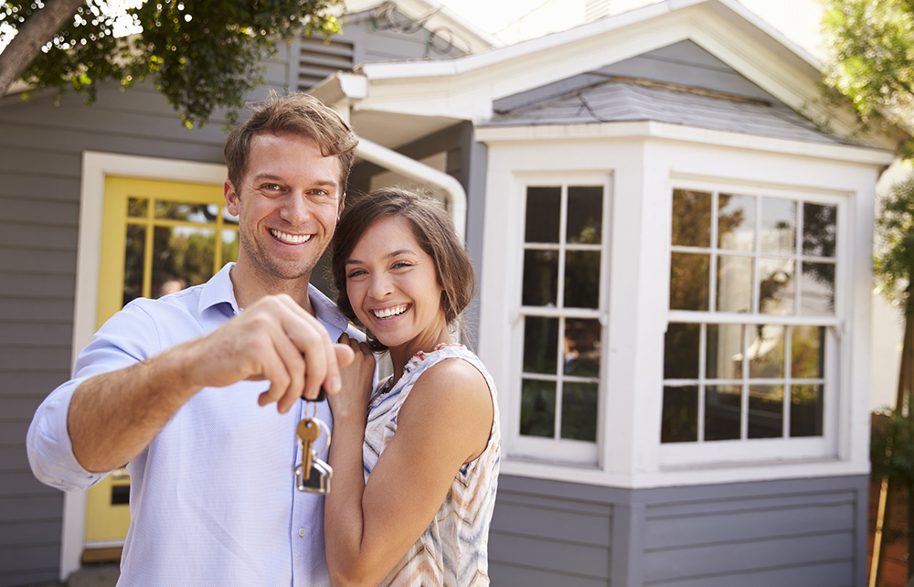 Couple holding keys to their first home