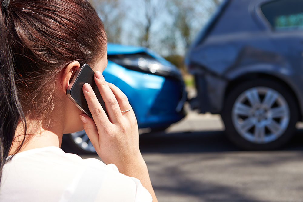 Woman makes phone call after car crash.