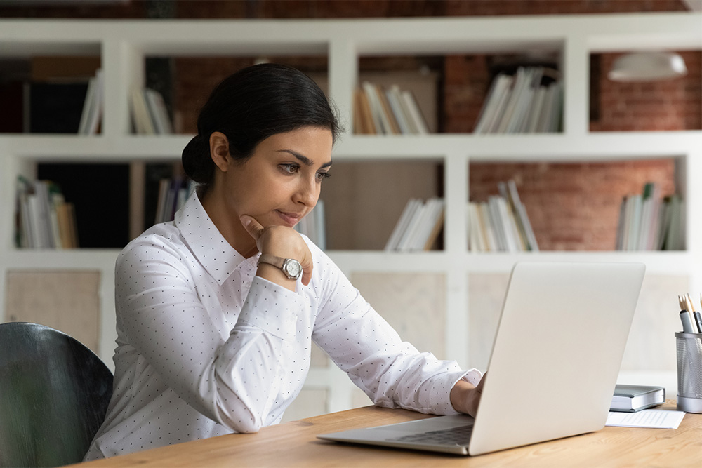 Young woman looking concerned at laptop.