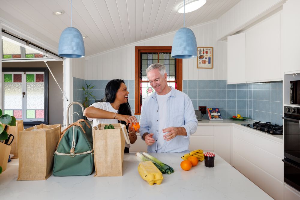 Couple unpacking grocery bag on kitchen bench