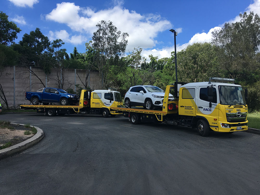 Roadside Assistance trucks with vehicles on the back during 2022 Brisbane flood.