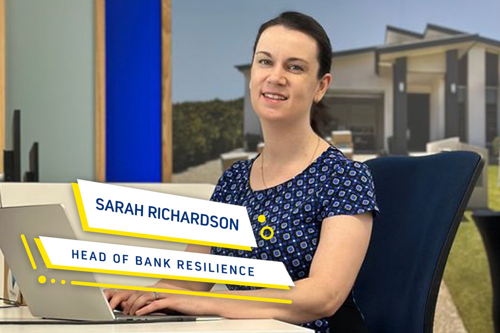 A lady sitting at a desk. Her name and title are written on the picture. Sarah Richardson. Head of Bank Resilience.