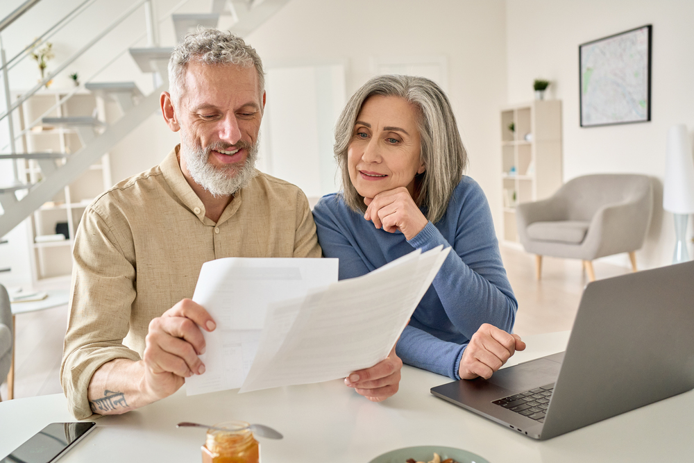Older couple with laptop and papers