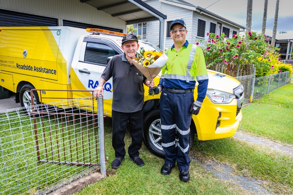 Patrol officer giving a member flowers in front of patrol vehicle