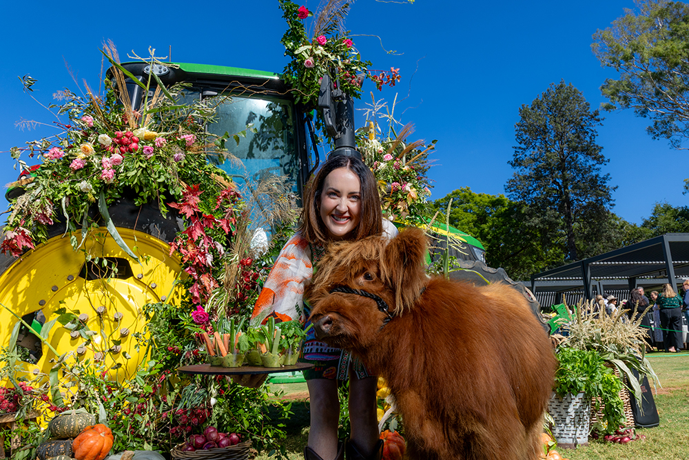 Girl with Highland cow calf promoting Scenic Rim Eat Local Month 2026.