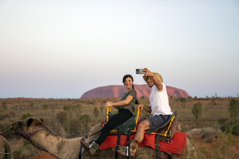 Camel ride with Uluru in background
