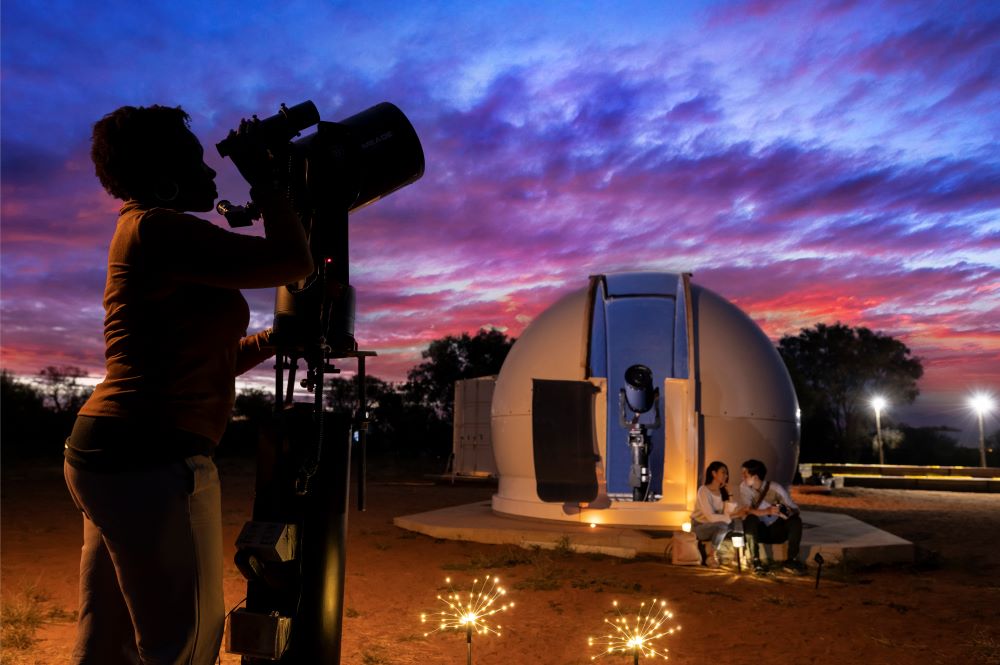A person looking through a telescope at the Dark Skies Festival.