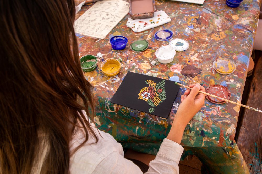 A woman painting at a Maruku art workshop.
