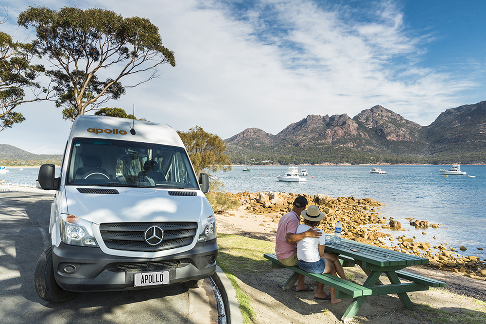 Couple picnicking by the water with Apollo van