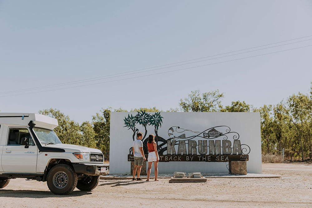Tourists check out the Karumba sign.