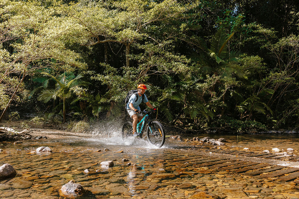 Mountain biker goes through a creek in Conway National Park.