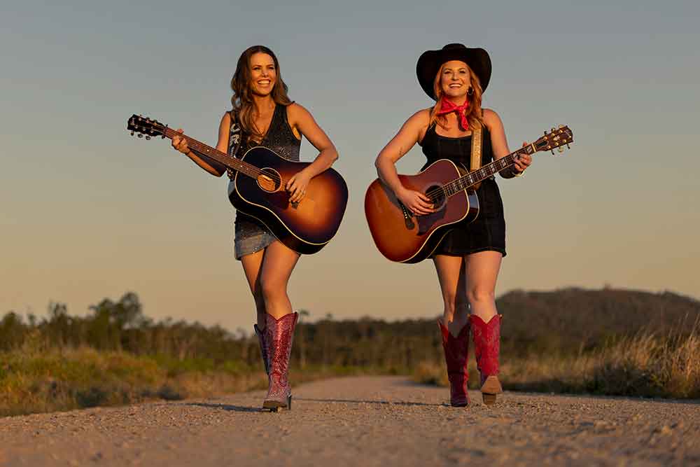 Qld Music Trails The Outback promotional image of two girls with guitars.